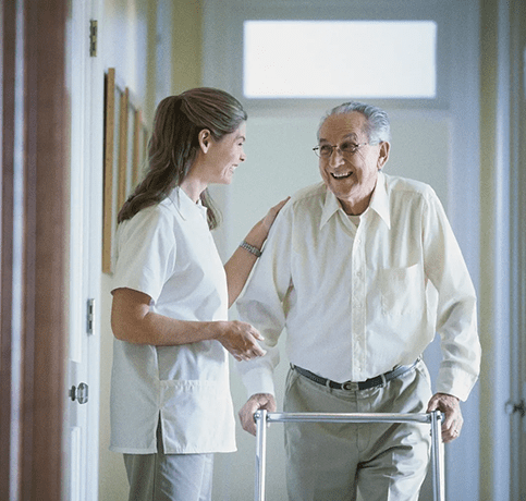 A nurse and an old man in a hallway