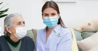 A woman wearing a face mask sitting on the couch