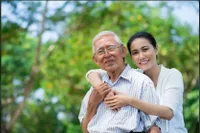 A woman and an old man are smiling for the camera.