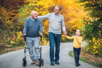 A man walking with two men and a child.