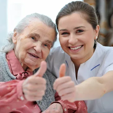 A woman and an old lady giving thumbs up.