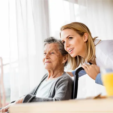 A woman and an old lady sitting at a table.