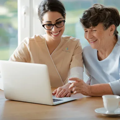 A woman and an older person looking at a laptop