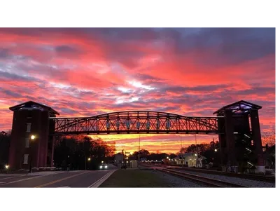 A bridge that is under an orange sky.