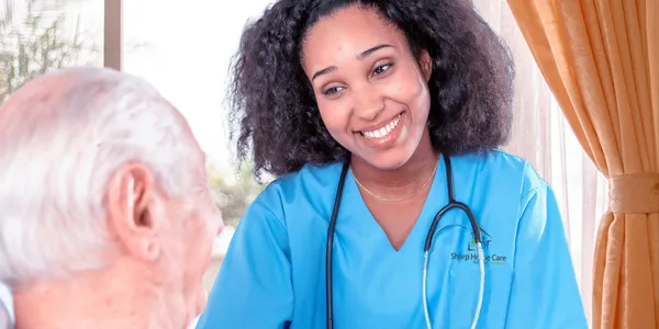 A woman in scrubs smiling for the camera.