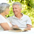 A man and woman sitting at the table with an open book.