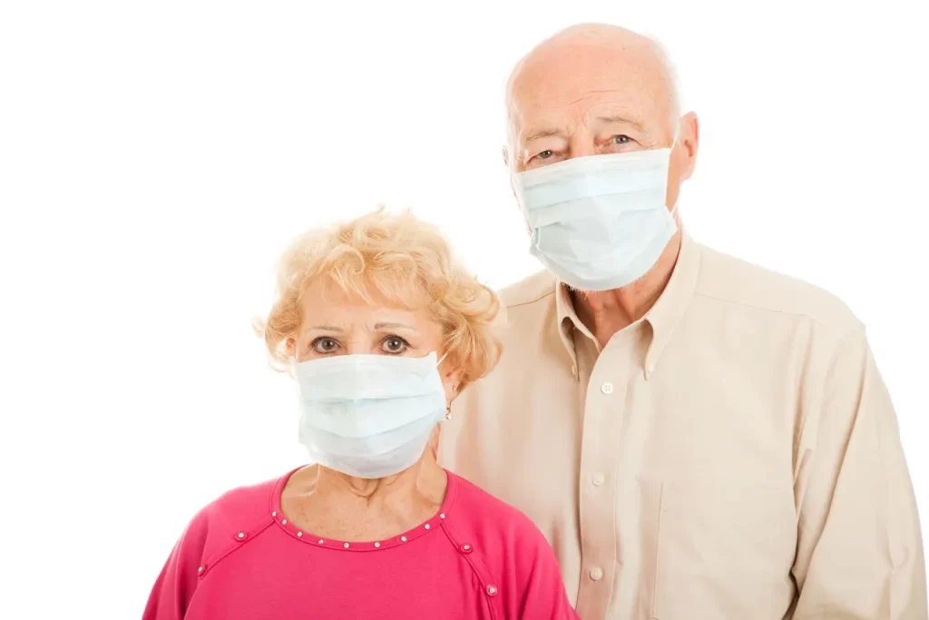 A man and woman wearing masks standing next to each other.