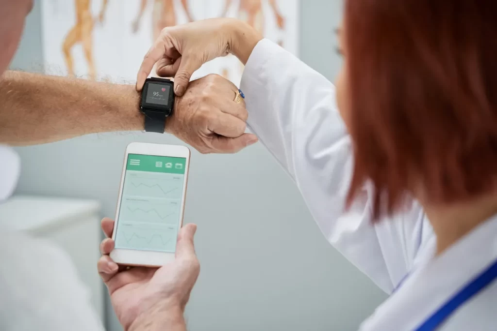 A doctor showing someone how to use their smart watch.