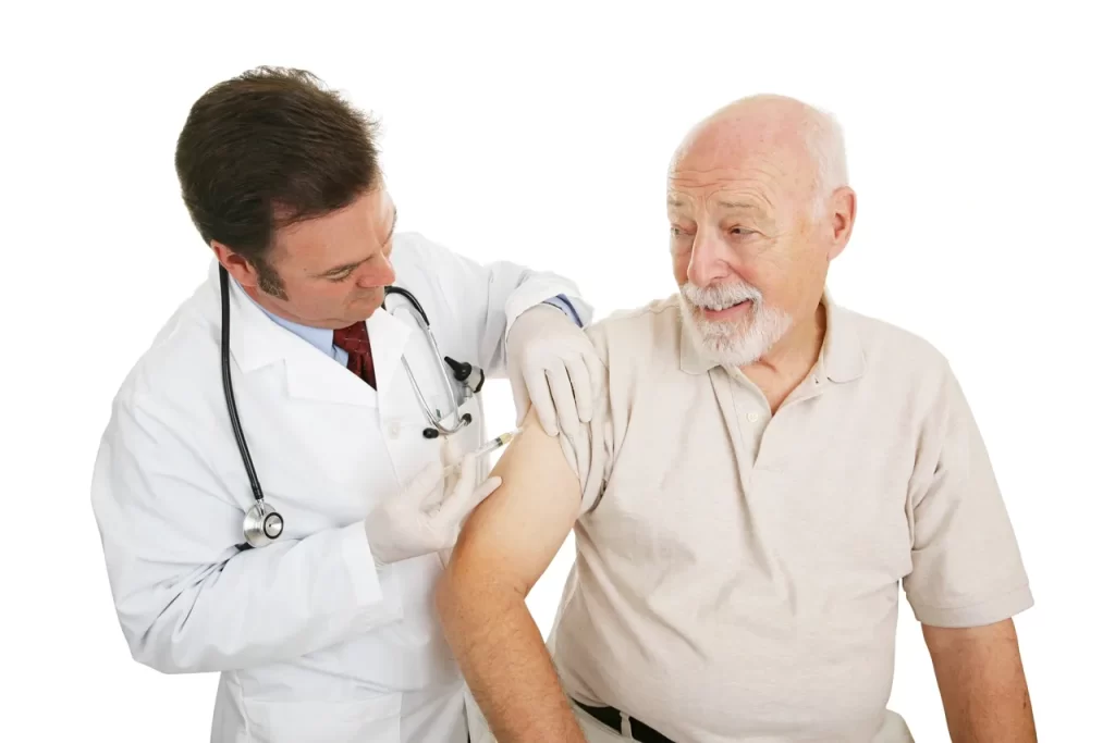 A doctor is giving an older man the flu shot.