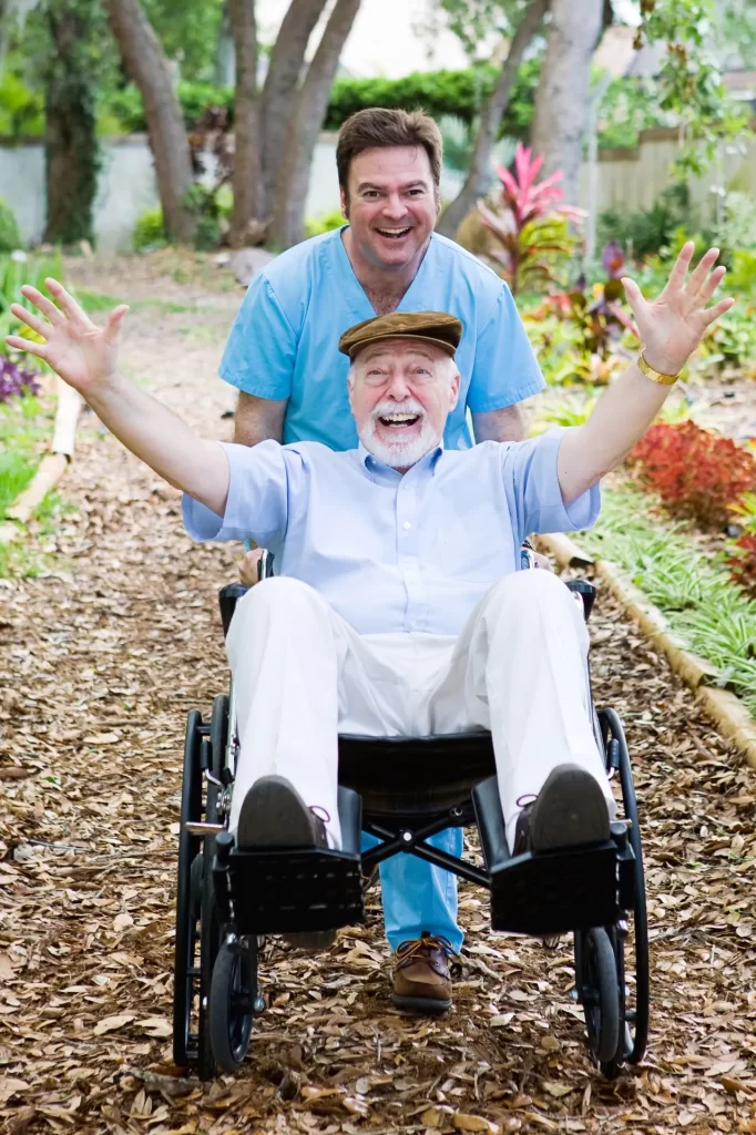 A man pushing an older gentleman in a wheelchair.