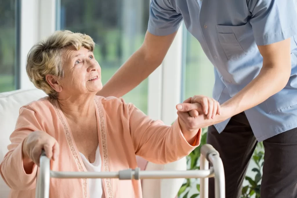 A man helping an older woman in a wheelchair.