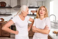 Two women in white shirts are standing next to each other.