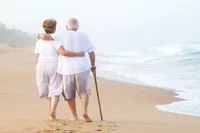 A man and woman walking on the beach