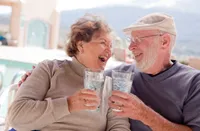 A man and woman holding glasses of water.